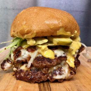 The All American Burger: Two Angus beef patties with melting American cheese, chopped bacon, shredded lettuce, pickles, red onions, mayo and yellow mustard