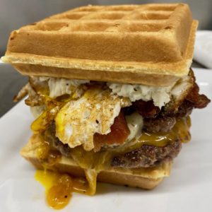 Double Waffle Double: Double bacon cheeseburger topped with sriracha spiked maple syrup and an over easy fried egg between two warm Belgian waffles slathered with “everything bagel” cream cheese