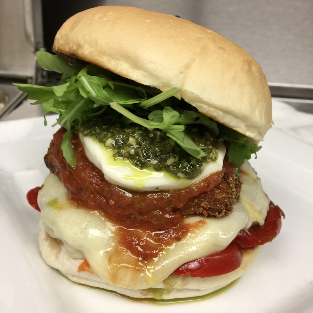 little pub mama leone’s burger topped with melting provolone, italian breadcrumbed chicken cutlet, marinara. house made mozzarella, hot cherry peppers, baby arugula, and a fresh basil pesto