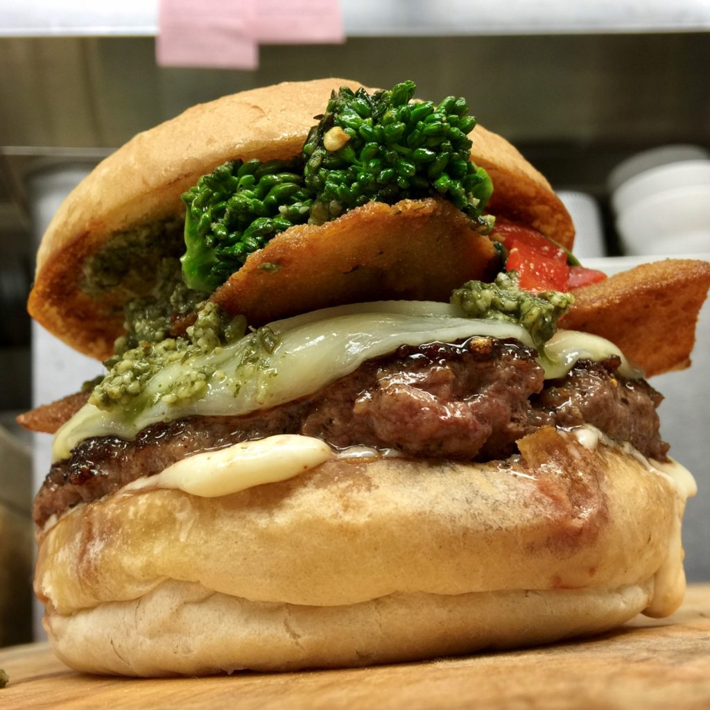Little Pub Arthur Ave Burger fresh ground, hand packed angus beef topped with melting provolone, crispy breaded eggplant, sautéed broccoli rabe, roasted peppers, our “heavy on the garlic” garlic aioli and a fresh basil pesto