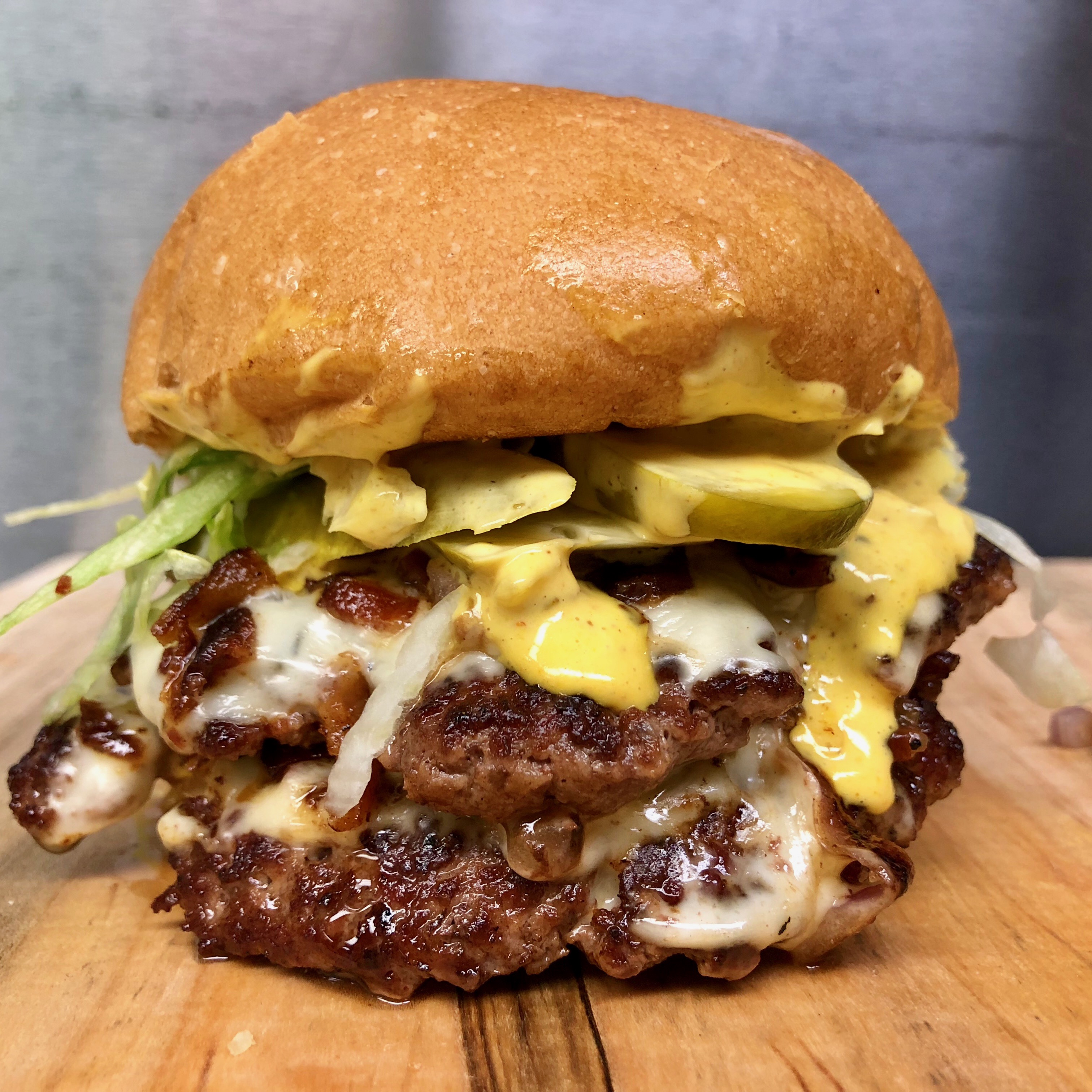 Little Pub Drive Thru Double Feature Burger : Two 4oz patties, steamed onions, american cheese, chopped bacon, shredded lettuce, sliced pickles and Little Pub secret sauce 
