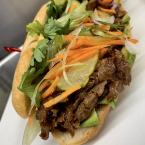 Philli Styl Banh Mi at Little Pub: Ginger soy marinated shaved steak on a grinder roll topped with pickled vegetables, sliced avocado, and sriracha aioli